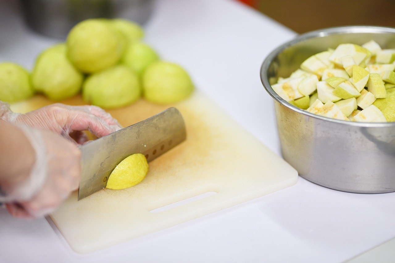 Fresh Guava Preparation: Slicing Fruit for Healthy Snacks - Ko Lake Villa boutique lakefront accommodation on Koggala Lake Sri Lanka: Discover fresh guava being expertly sliced on a cutting board, ready for healthy snacks or recipes. Perfect for fruit lovers & food preparation content.