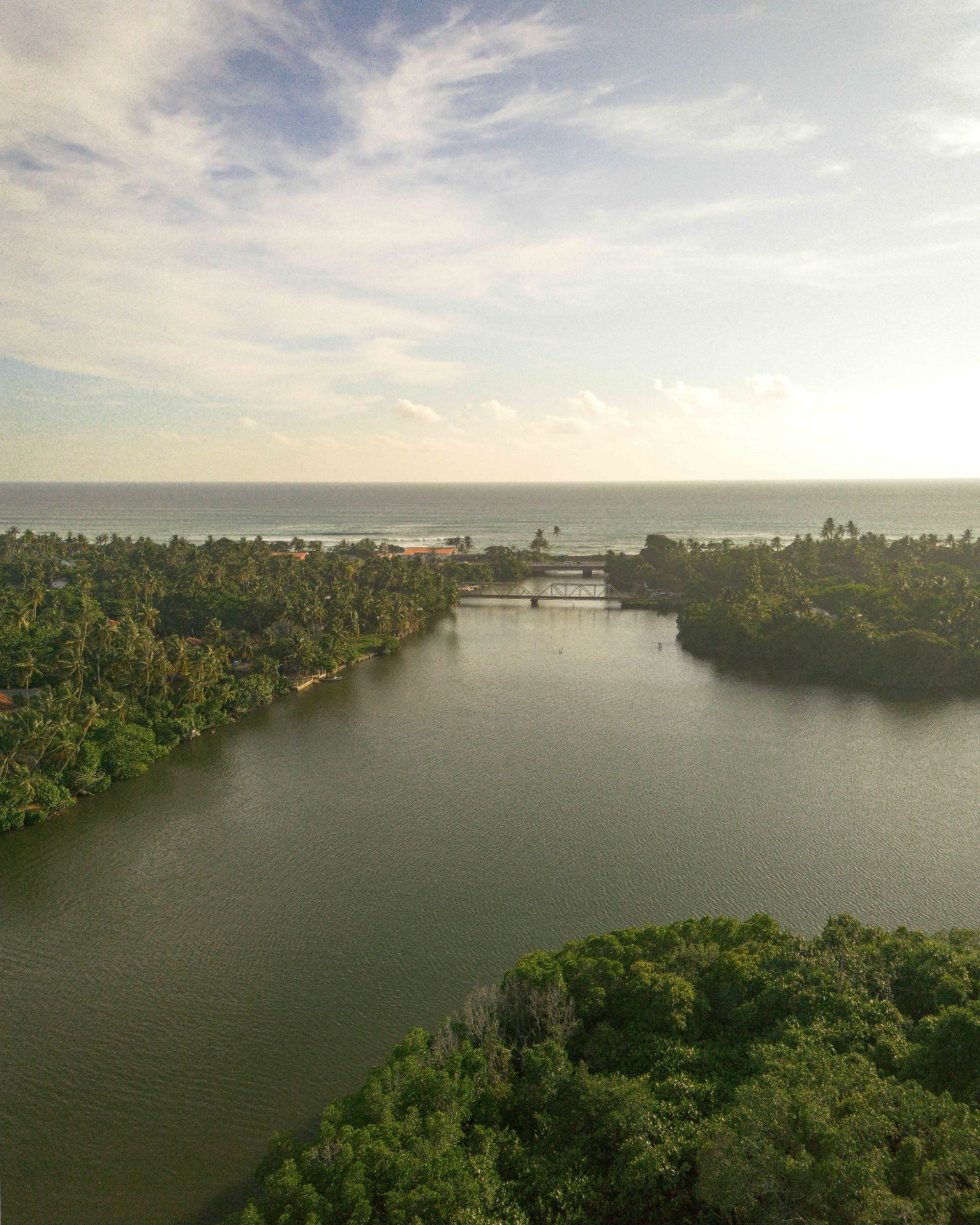 Stunning Sunset Over Calm Ocean Horizon - Ko Lake Villa boutique lakefront accommodation on Koggala Lake Sri Lanka: Experience a breathtaking view with reflections over a peaceful lake meeting the sea horizon, perfect for nature lovers and photographers.