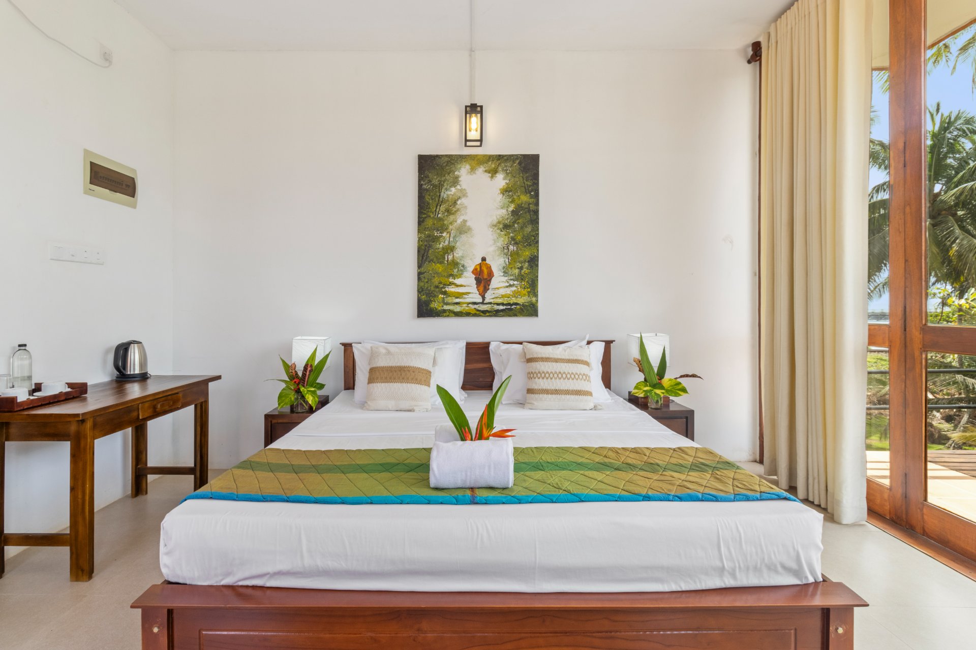 Inviting Tropical Bedroom with Balcony View - Ko Lake Villa boutique lakefront accommodation on Koggala Lake Sri Lanka: A spacious, bright bedroom featuring a queen bed, vibrant decor, and a balcony view. Perfect for a relaxing getaway to Sri Lanka. Overloops large wrap balcony, lush gardens, lake and bridge