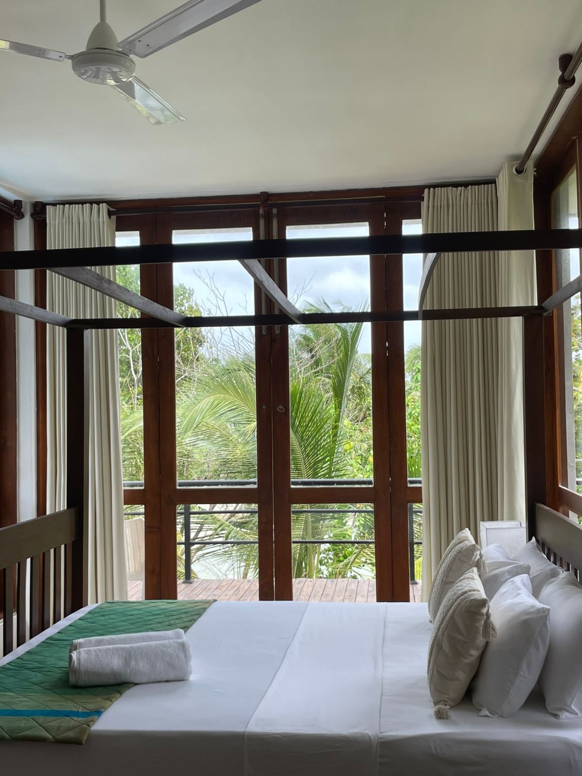 Highlake r6 : Lakeside Bedroom with 2nd floor Balcony View - Ko Lake Villa boutique lakefront accommodation on Koggala Lake Sri Lanka: Relax in this serene bedroom featuring a four-poster bed, direct balcony access, and lush tropical lake views. Perfect for a calming escape.