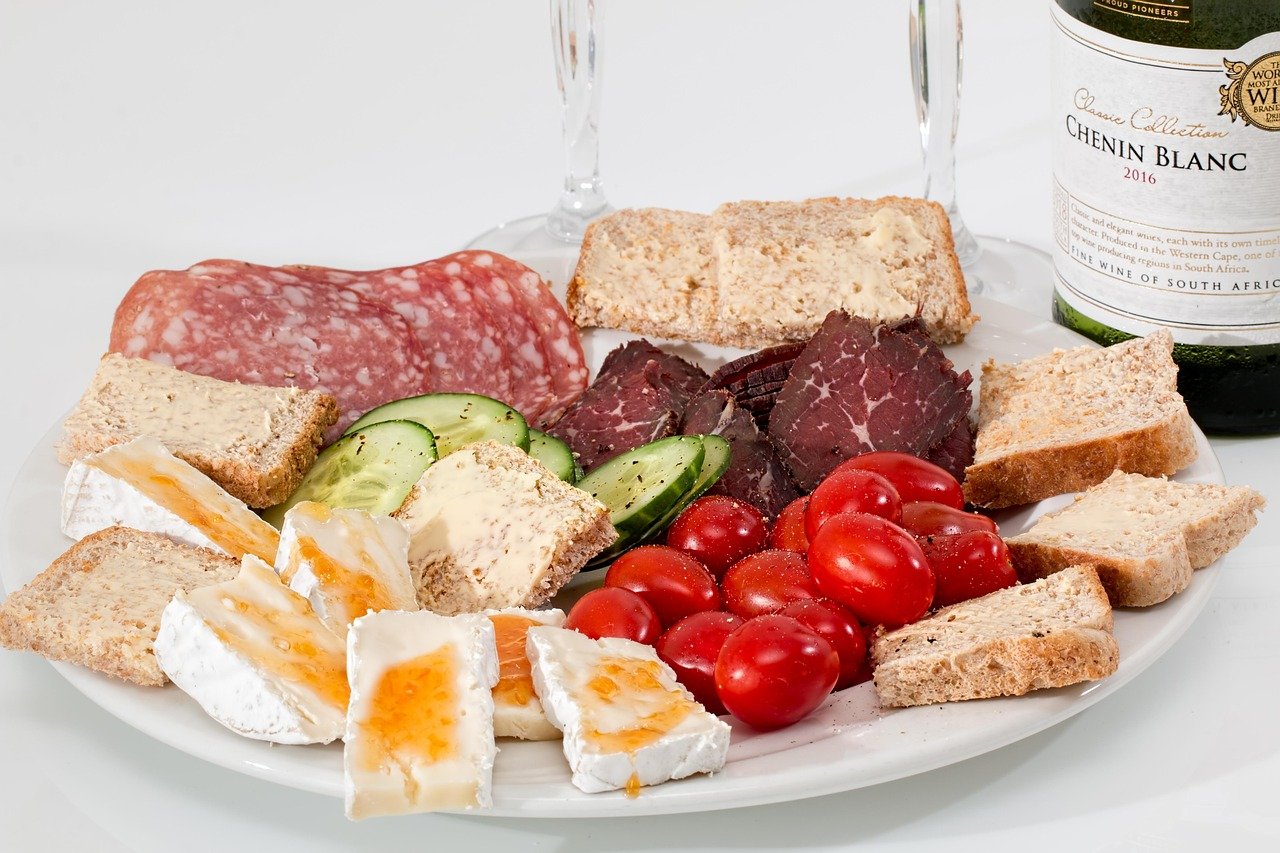 Gourmet Charcuterie Board & Chenin Blanc Wine - Ko Lake Villa boutique lakefront accommodation on Koggala Lake Sri Lanka: Appetizer spread with salami, biltong, cheese, cherry tomatoes, and cucumber, perfectly paired with a Chenin Blanc wine.