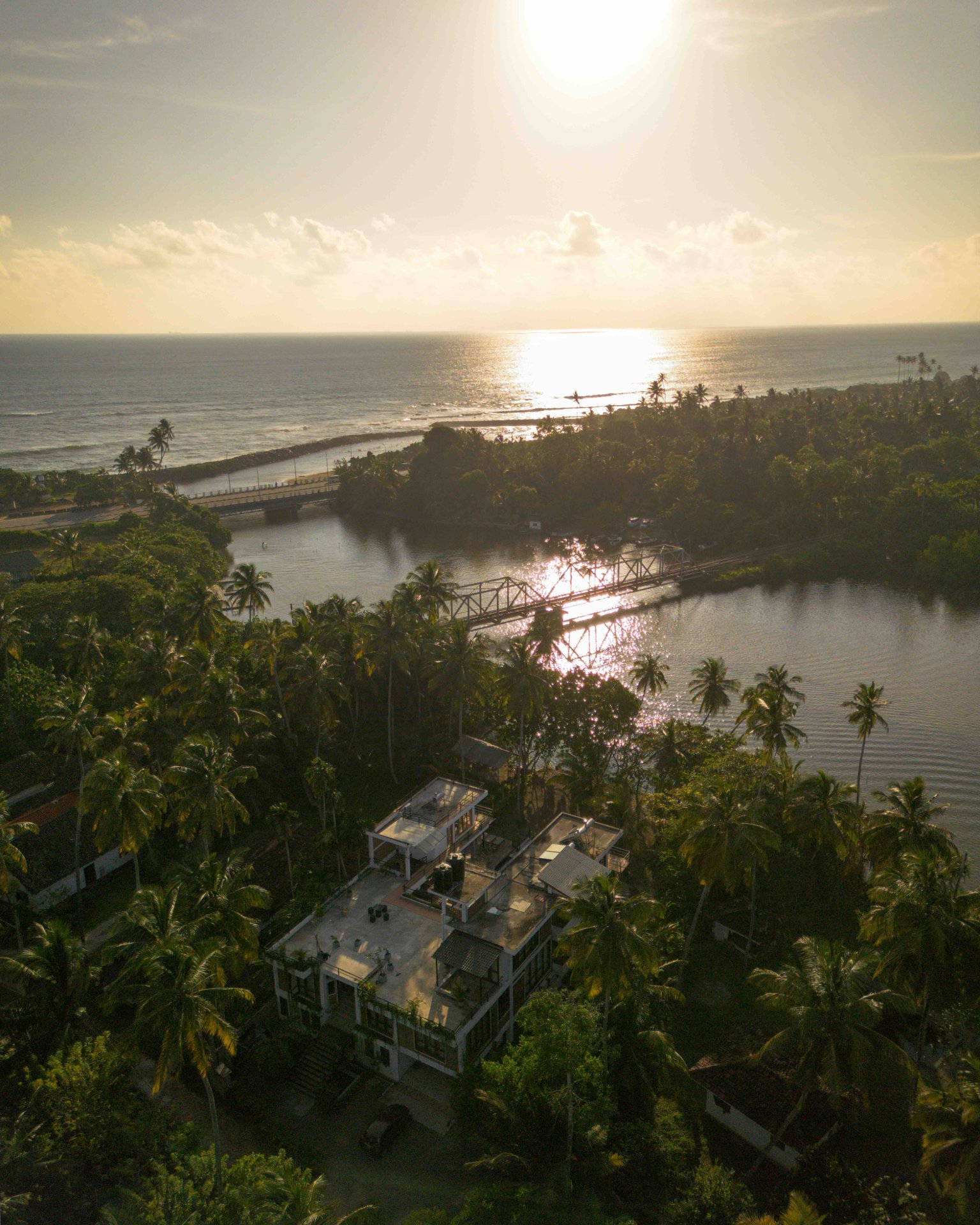 Aerial View of Coastal Landscape with Waves - Ko Lake Villa boutique lakefront accommodation on Koggala Lake Sri Lanka: Stunning aerial shot of a rocky coastline with blue ocean waves crashing against the shore.