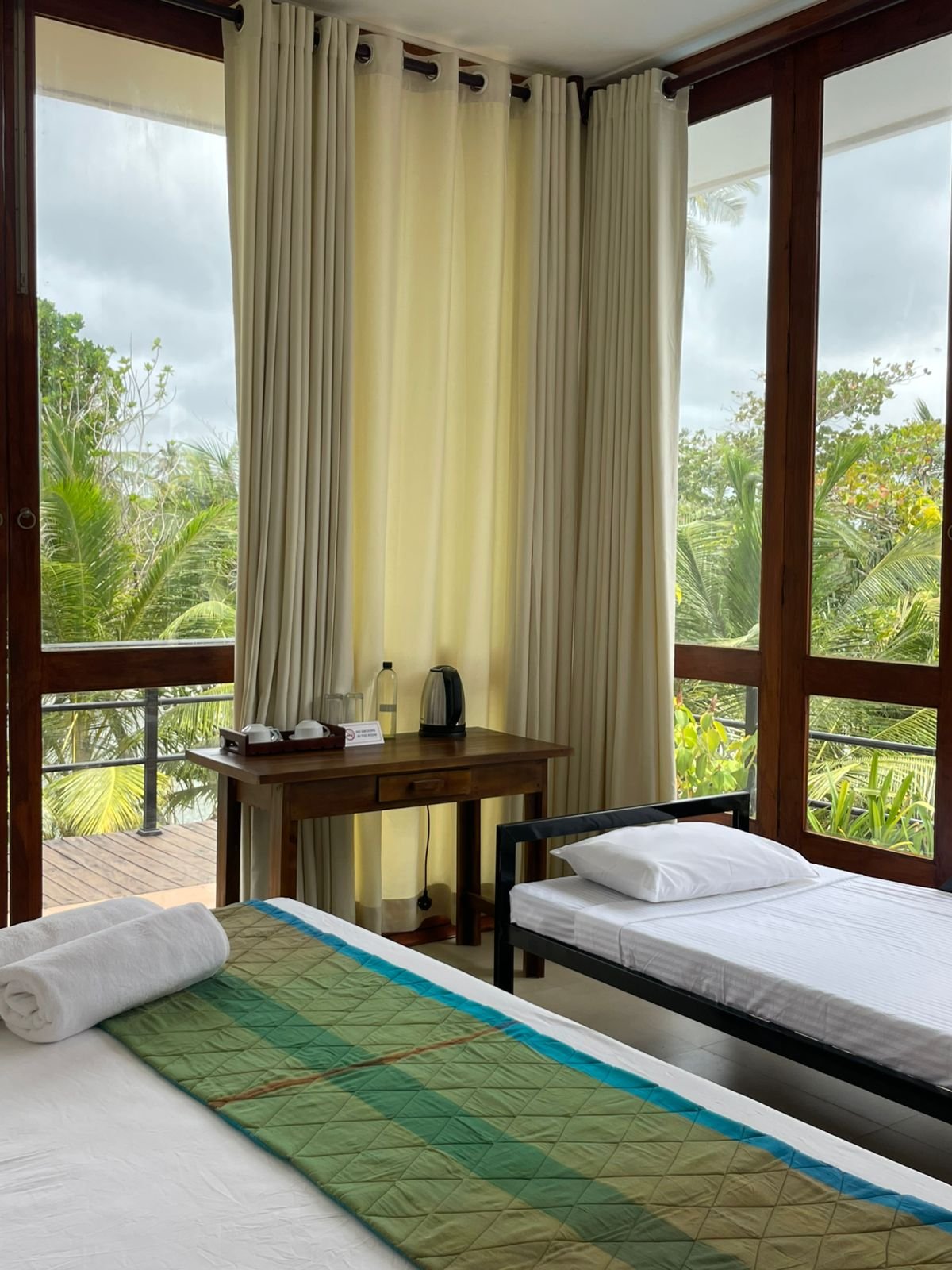 Eagle Nest r5: Balcony View - Ko Lake Villa boutique lakefront accommodation on Koggala Lake Sri Lanka: Experience a serene room featuring super king and sofabed, a private wrap-around balcony with lush tropical views, and convenient in-room amenities for tea/coffee. Perfect for a relaxing getaway.